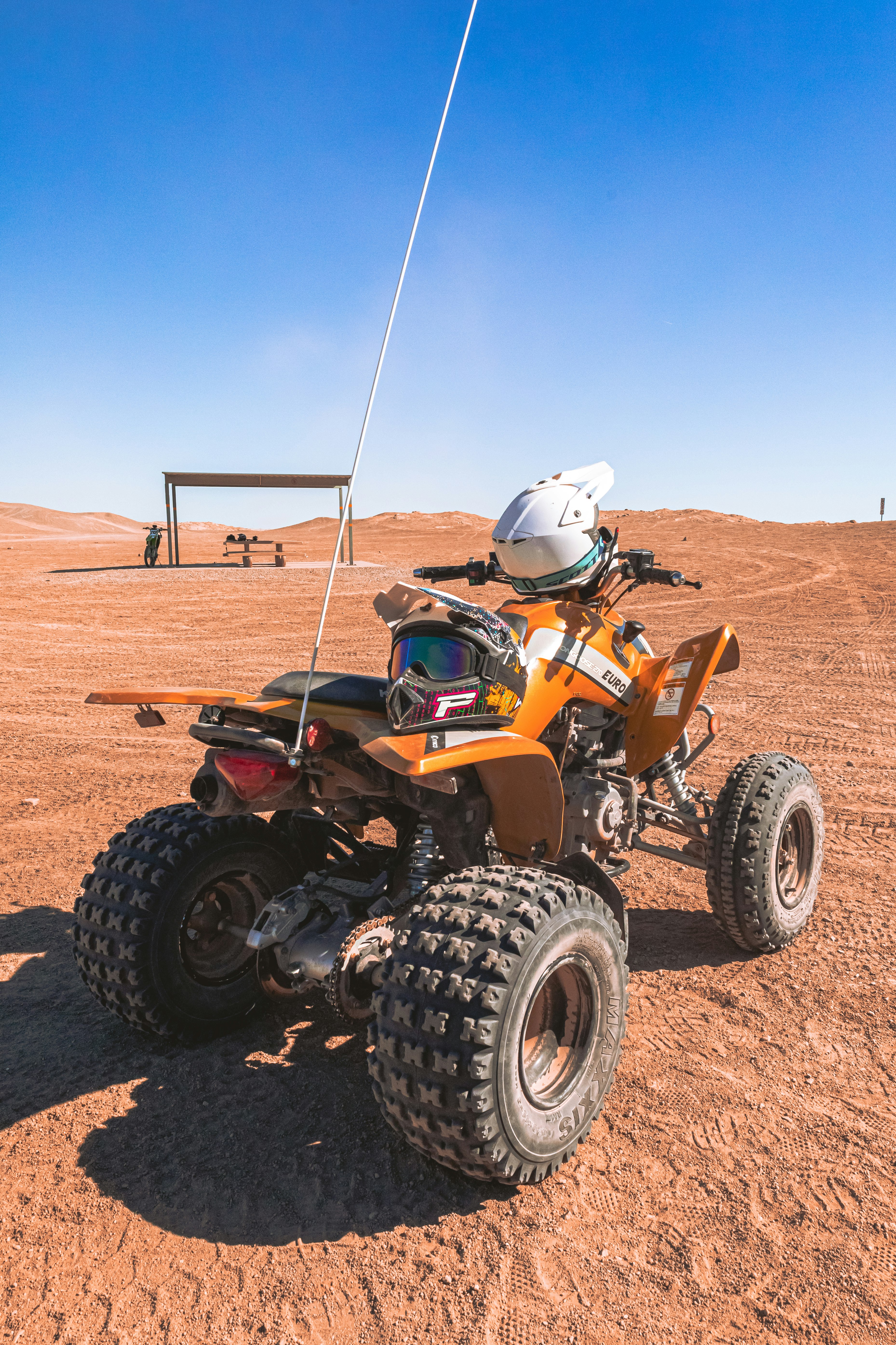 orange and black atv on brown sand during daytime